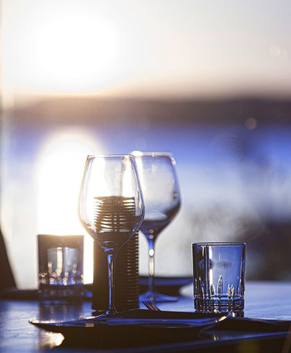 Gedeckter Tisch mit Weingläsern am Meer
